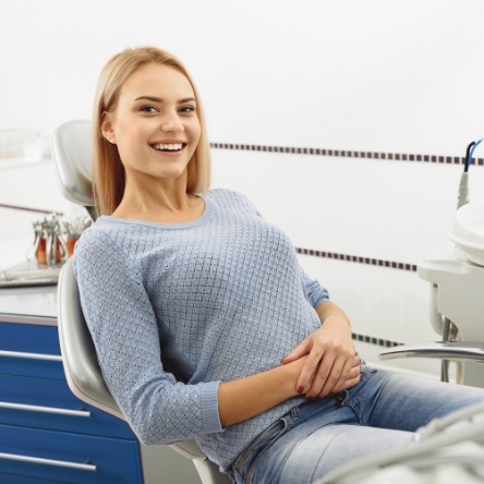 Woman sitting back in dental chair and smiling