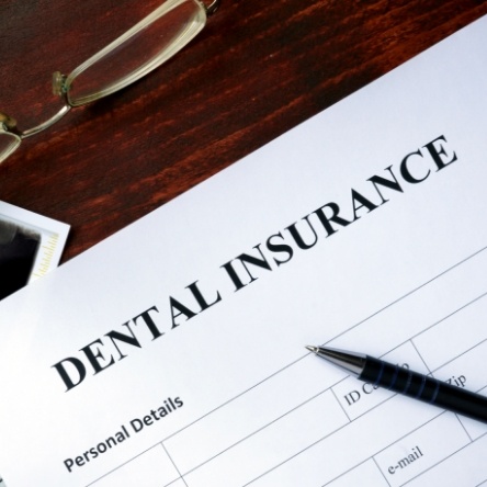 Dental insurance on wooden desk with pen