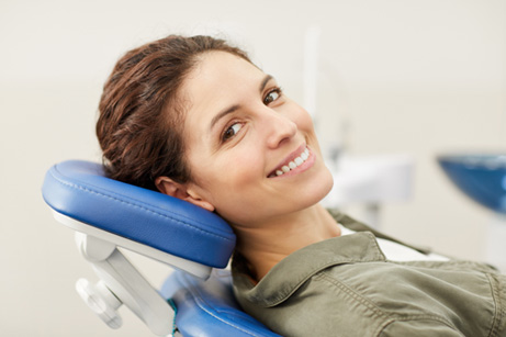 Smiling woman leaning back in the dental chair