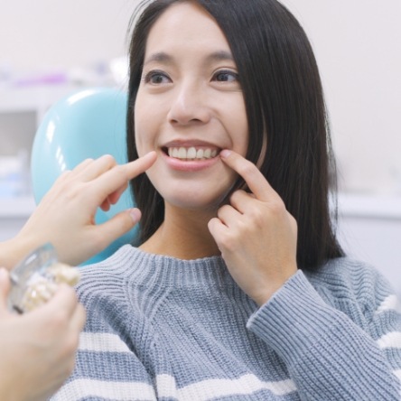 Female dental patient pointing to her smile