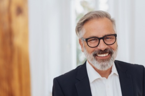 Man with suit and glasses smiling