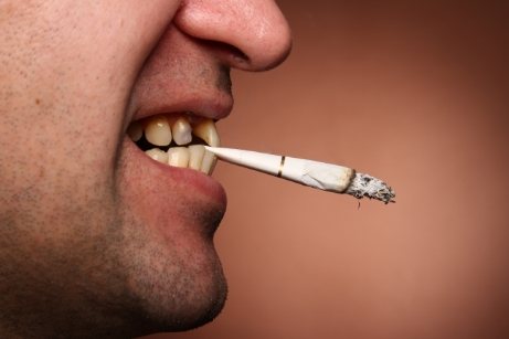 Close up of man biting down on cigarette