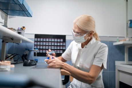 Woman with mask working on dental implant restoration