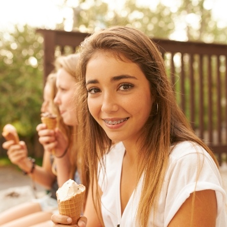 Girl sitting on steps eating ice cream with friends