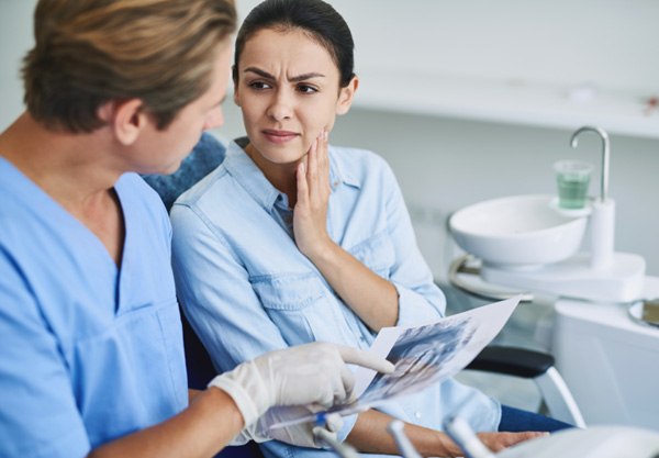 Patient in Balch Springs holding cheek at dentist