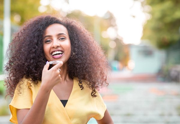 Patient in Balch Springs holding Invisalign aligner