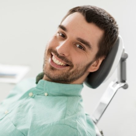 Male dental patient in light green shirt smiling