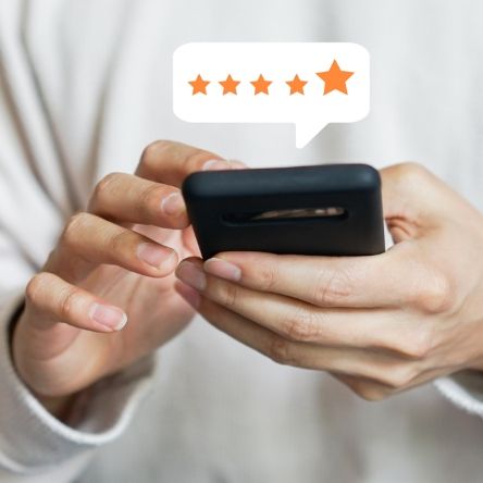 Man holding phone leaving five star review