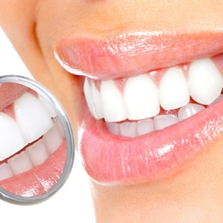 Close up of bright white teeth and dental mirror